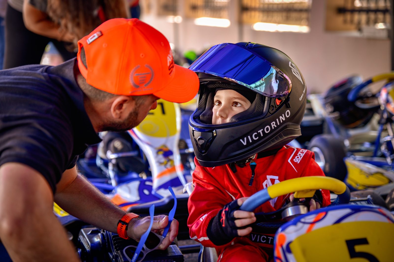 Victor în kart, cu casca VICTORINO, privindu-și tatăl